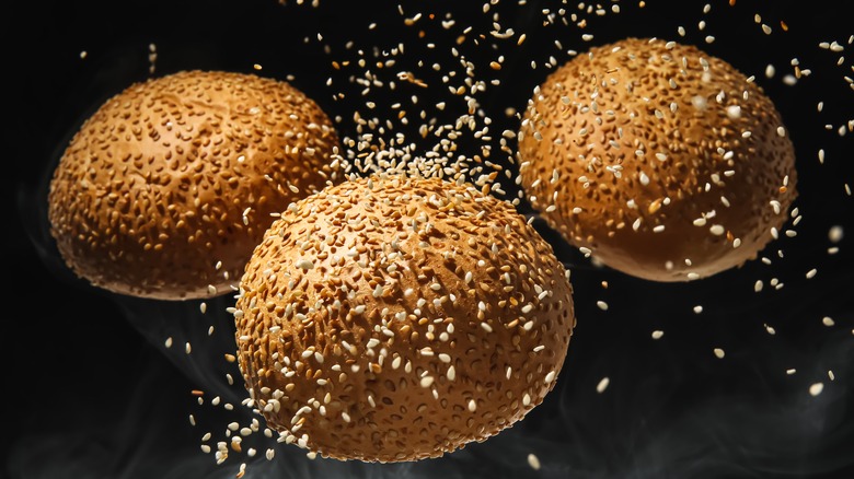 burger buns with falling sesame seeds