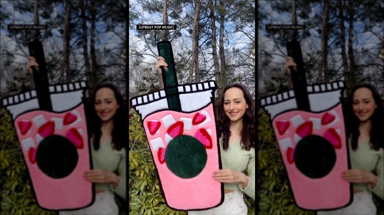 woman holding pink drink rug