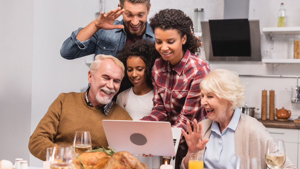 Family with laptop at Thanksgiving dinner