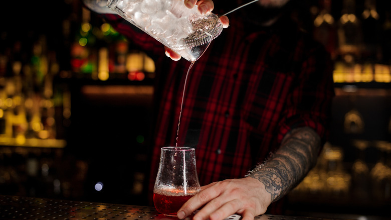 bartender pouring Sazerac cocktail 