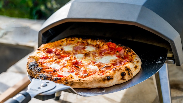 Pizza coming out of a pizza oven