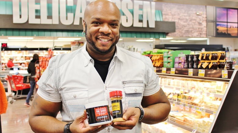 Aaron McCargo Jr. holds jars of spices