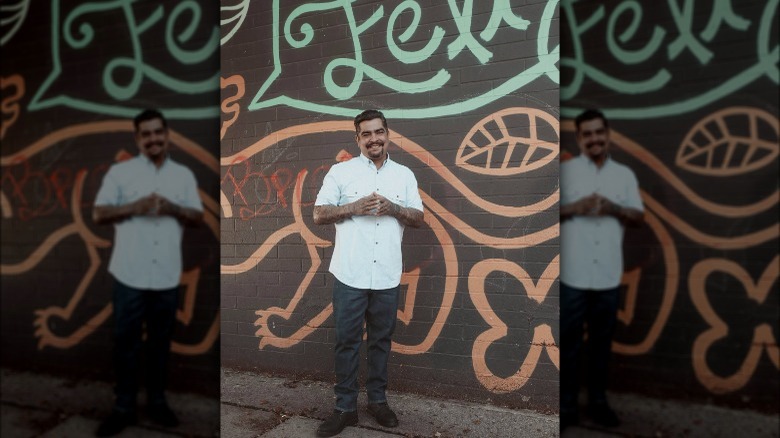 Aarón Sanchez in front of painted wall outdoors