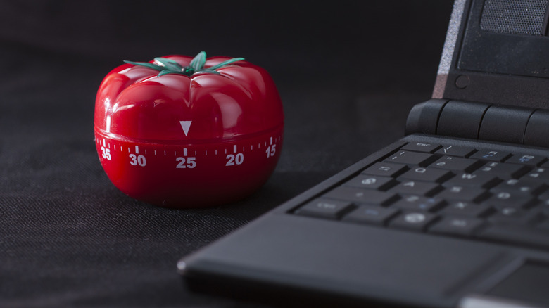 Kitchen timer alongside laptop