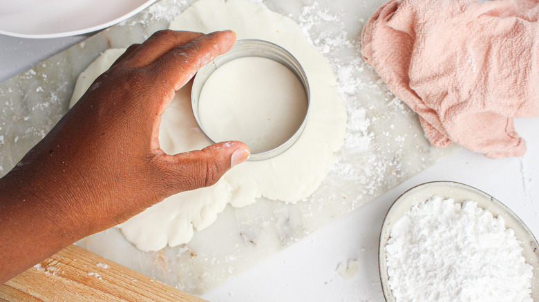 hand cutting out fondant circle