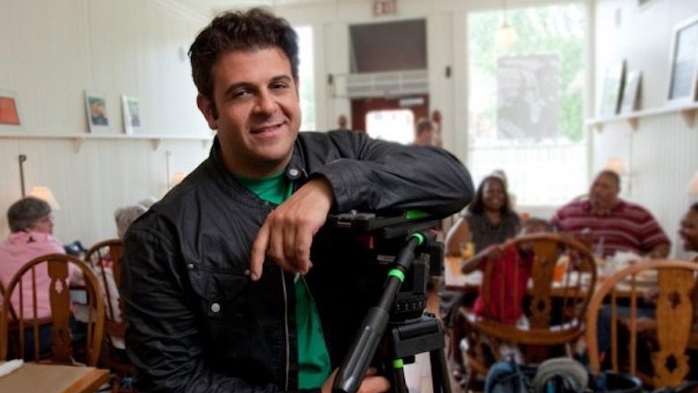 Adam Richman stands with camera