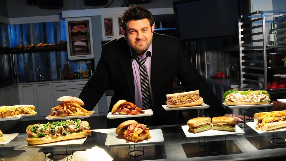 Former Man vs. Food host Adam Richman with plates of food