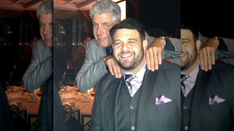 Anthony Bourdain squeezing Adam Richman's shoulders