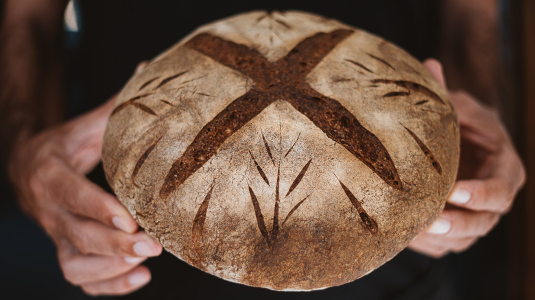 Hands holding sourdough bread