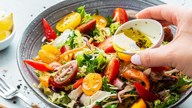 pouring dressing on salad