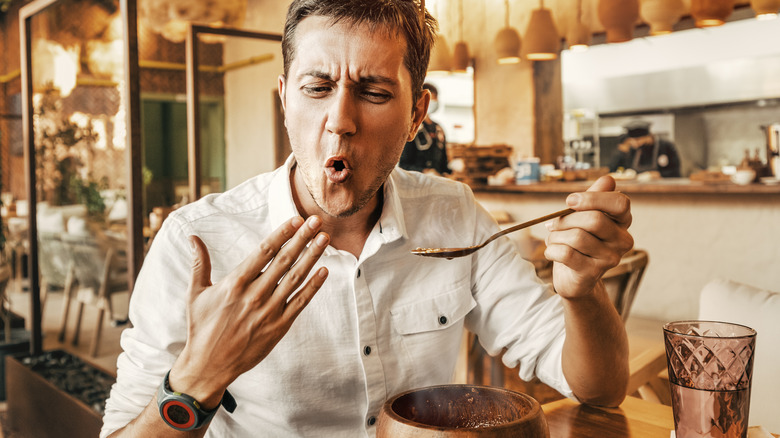 Man eating spicy food making a face