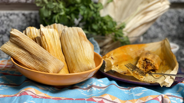 tamales in bowl and half eaten tamale on plate