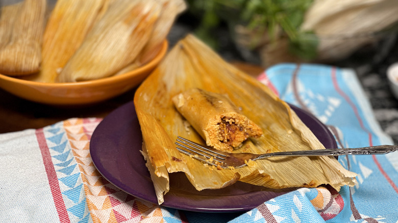 Half eaten chile and cheese tamale on plate