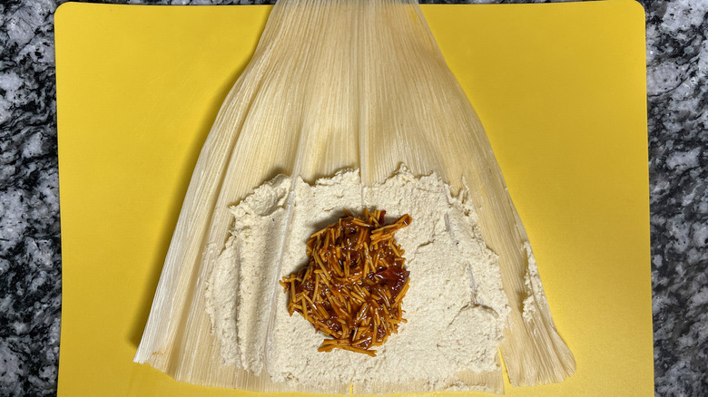 Chipotle cheese mixture layered on masa and corn husk