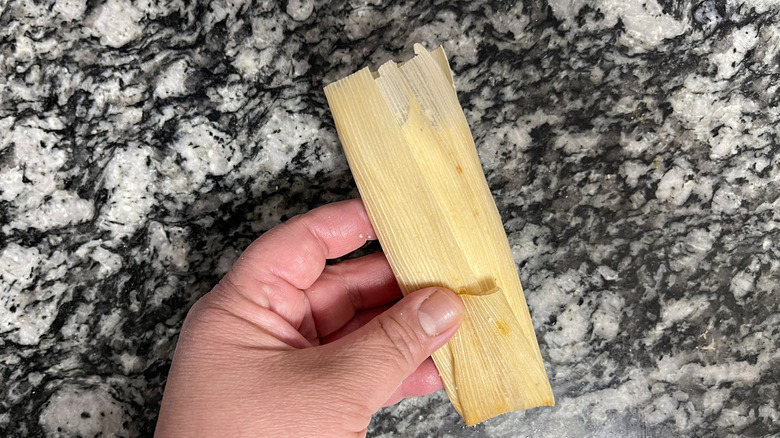 Hand folding corn husk with filling