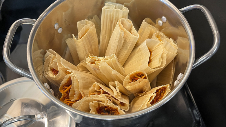 Uncooked tamales stacked in large pot