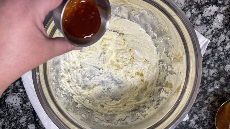 Pouring adobo sauce into whipped butter