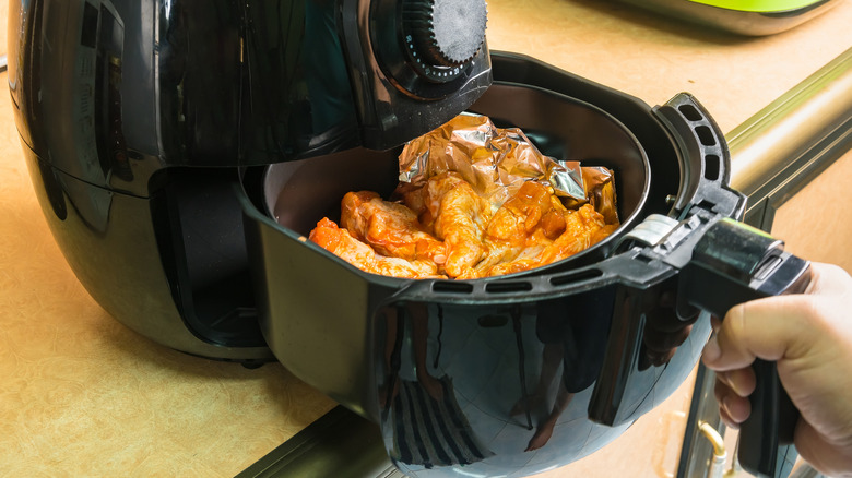 Person putting orange chicken in air fryer