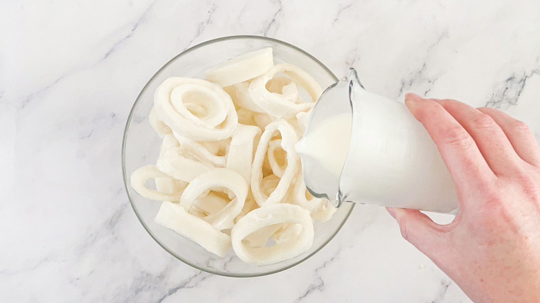 milk pouring into bowl of calamari