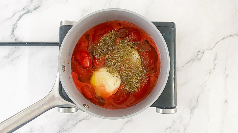 tomatoes, basil, onion in saucepan