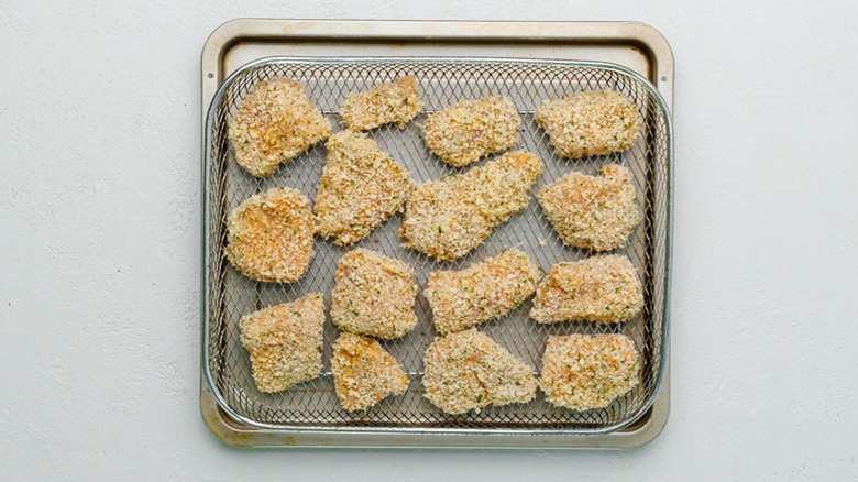 air fryer basket with breaded chicken nugget bites