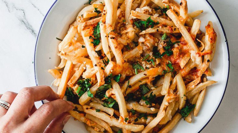 hand picking fry from plate