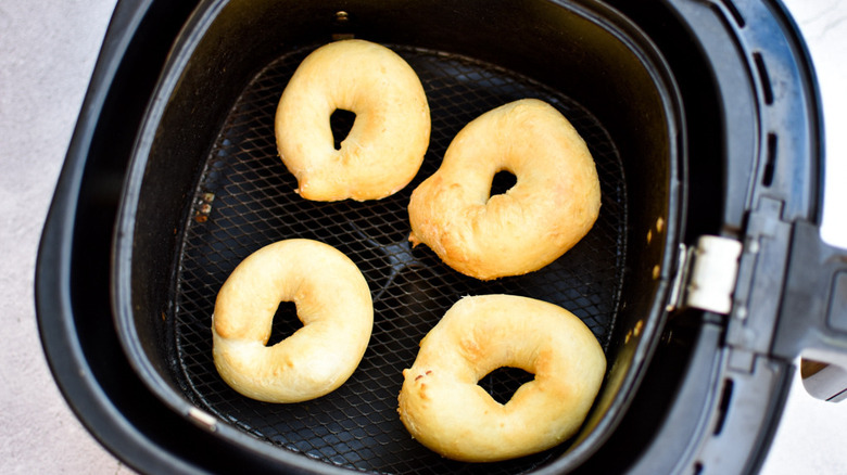 crispy golden brown bagels in an air fryer basket