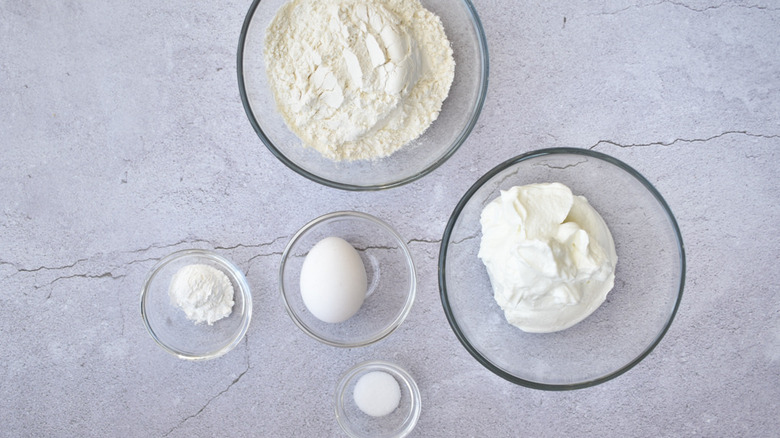 glass bowls filled with flour, baking powder, salt, Greek yogurt and an egg