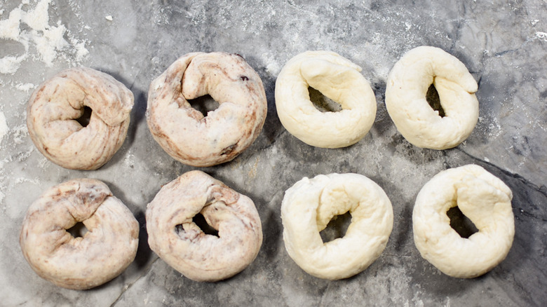 dough shaped into bagels on a gray marble counter