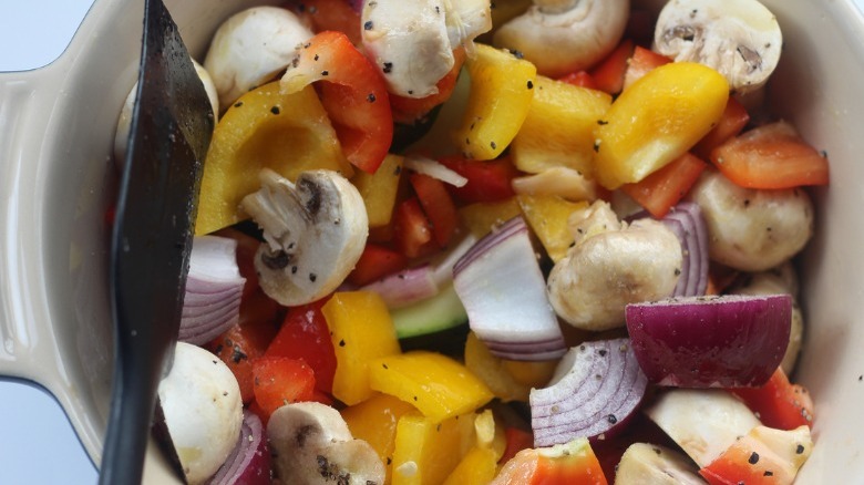 vegetables in a bowl with oil, salt, and pepper