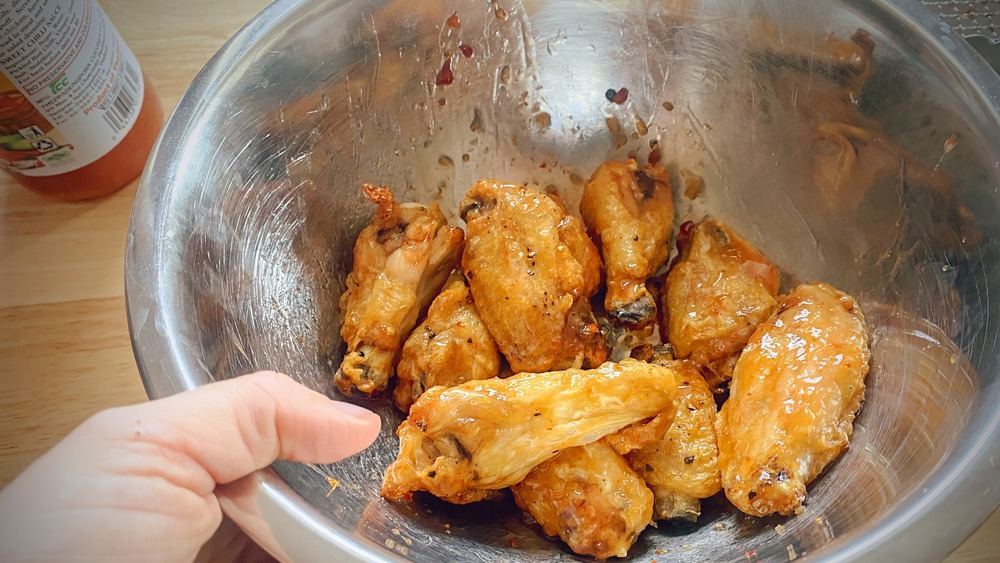 tossing air fryer sticky chicken wings in sauce