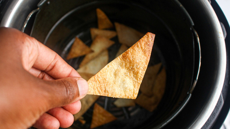 hand holding air fryer tortilla chip finished