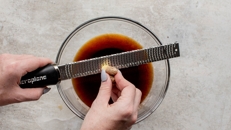 grating ginger into sauce