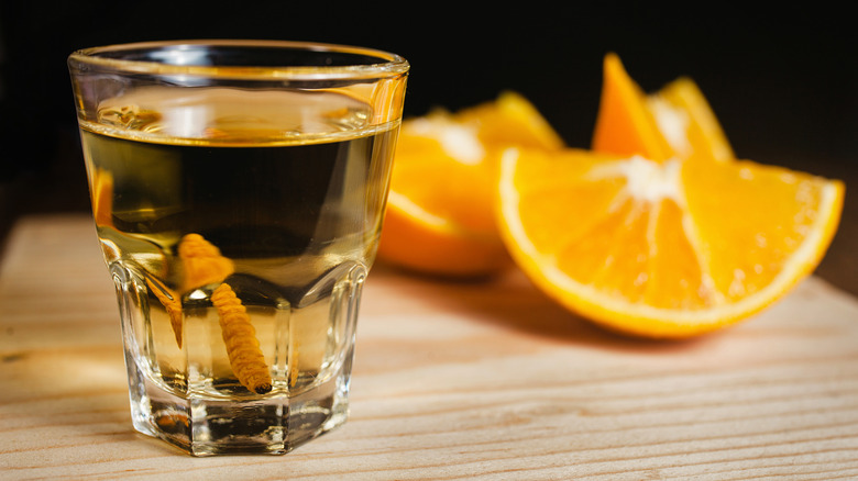 Mezcal shot on board with orange slices