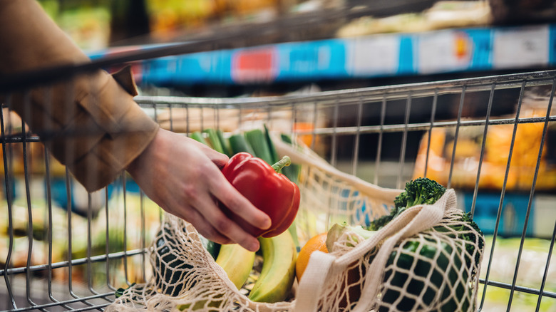 woman putting fruit in bag