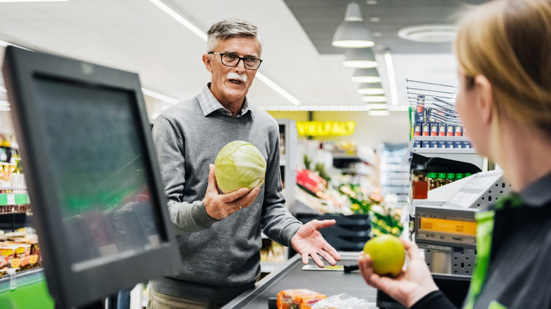 Man discussing groceries with cashier