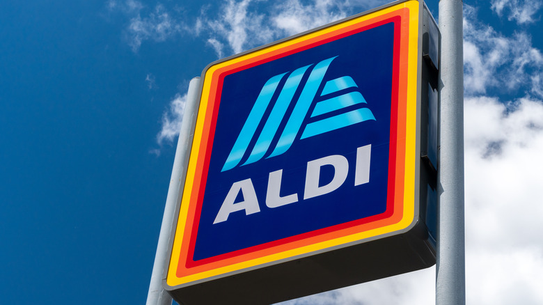 Aldi sign against blue sky and clouds