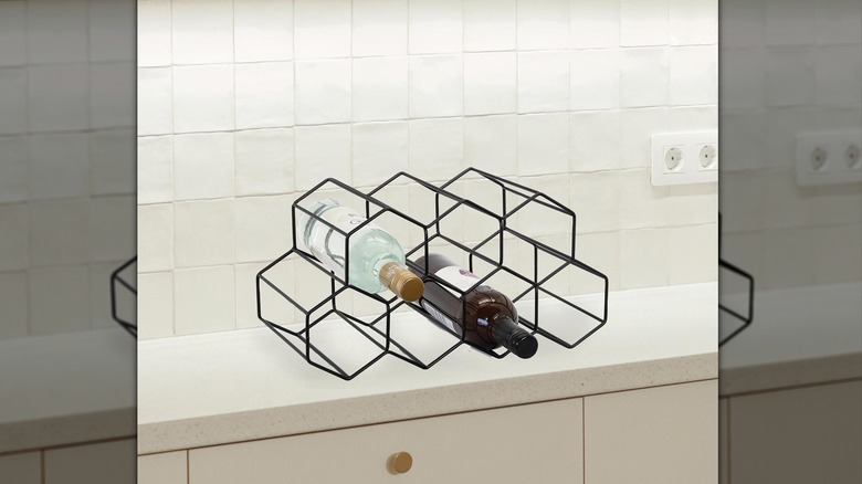 black wire wine rack with two wine bottles on counter