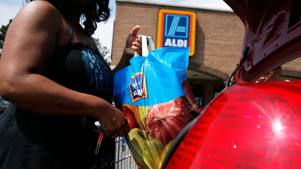 Shopper loading a bag into a car 