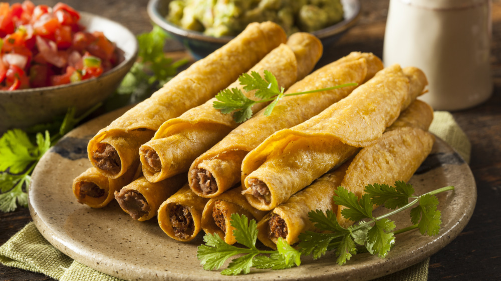 Beef taquitos stacked on plate