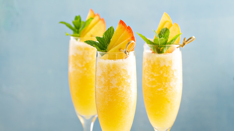 Sparkling wine in tall flutes with fruit wedges