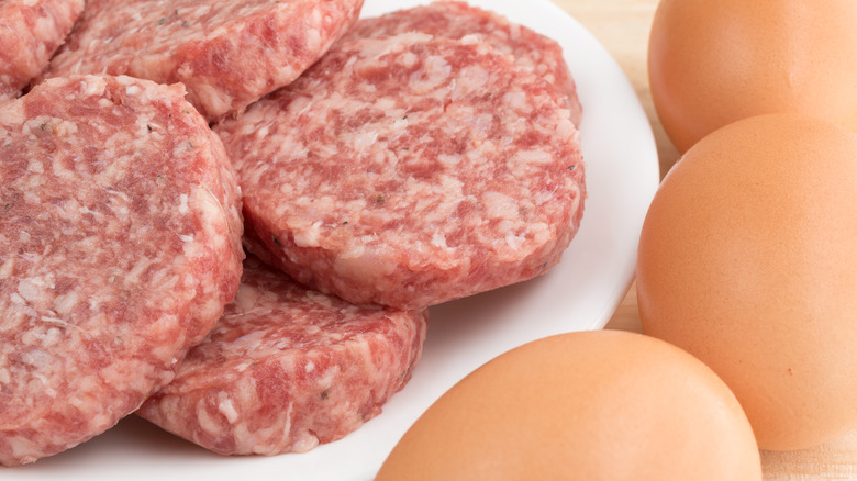 uncooked sausage on plate, eggs