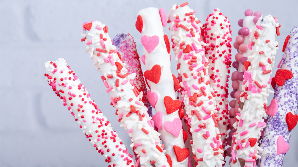 chocolate covered pretzel sticks with Valentine's sprinkles