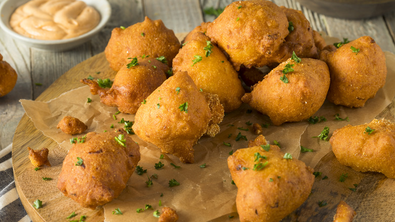 Hush puppies on wooden board with sauce 