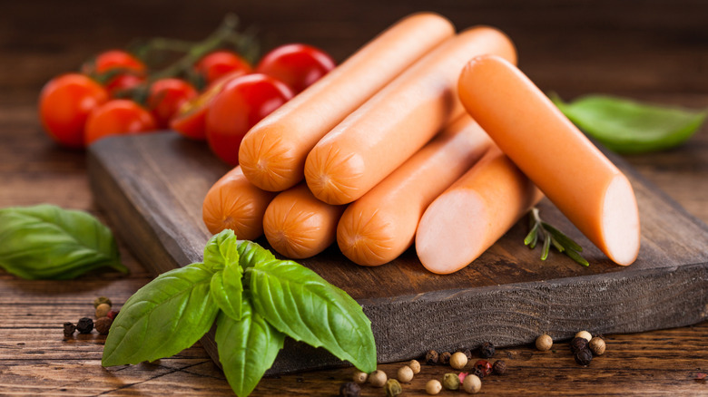 A pile of hot dogs on a cutting board