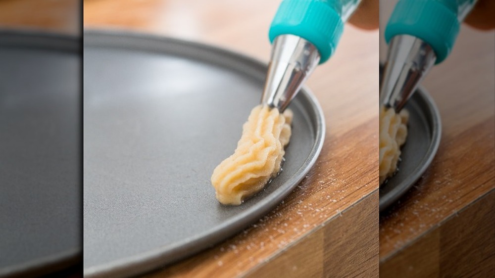 Piping out churro dough