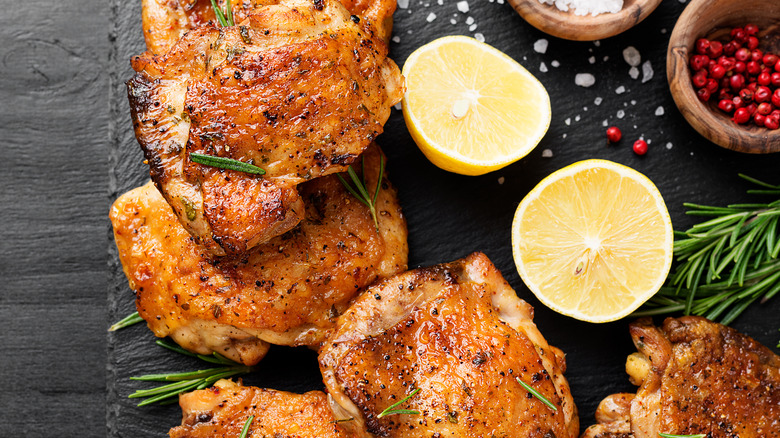 Crispy chicken on platter with lemons and herbs