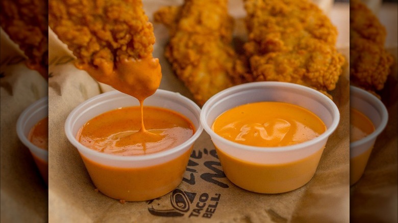 dipping chicken tenders in Taco Bell creamy jalapeno sauce