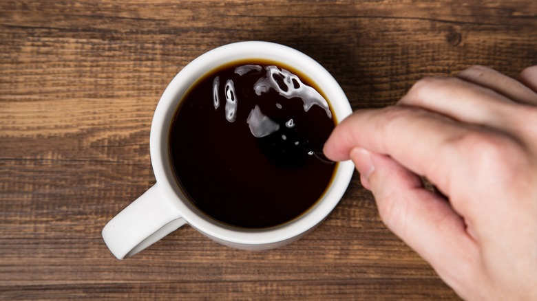 Person stirring coffee