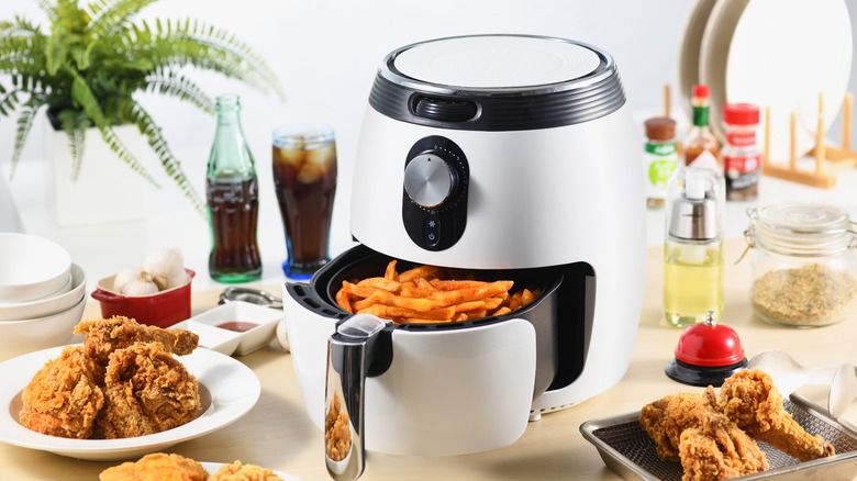 air fryer on table with fried chicken